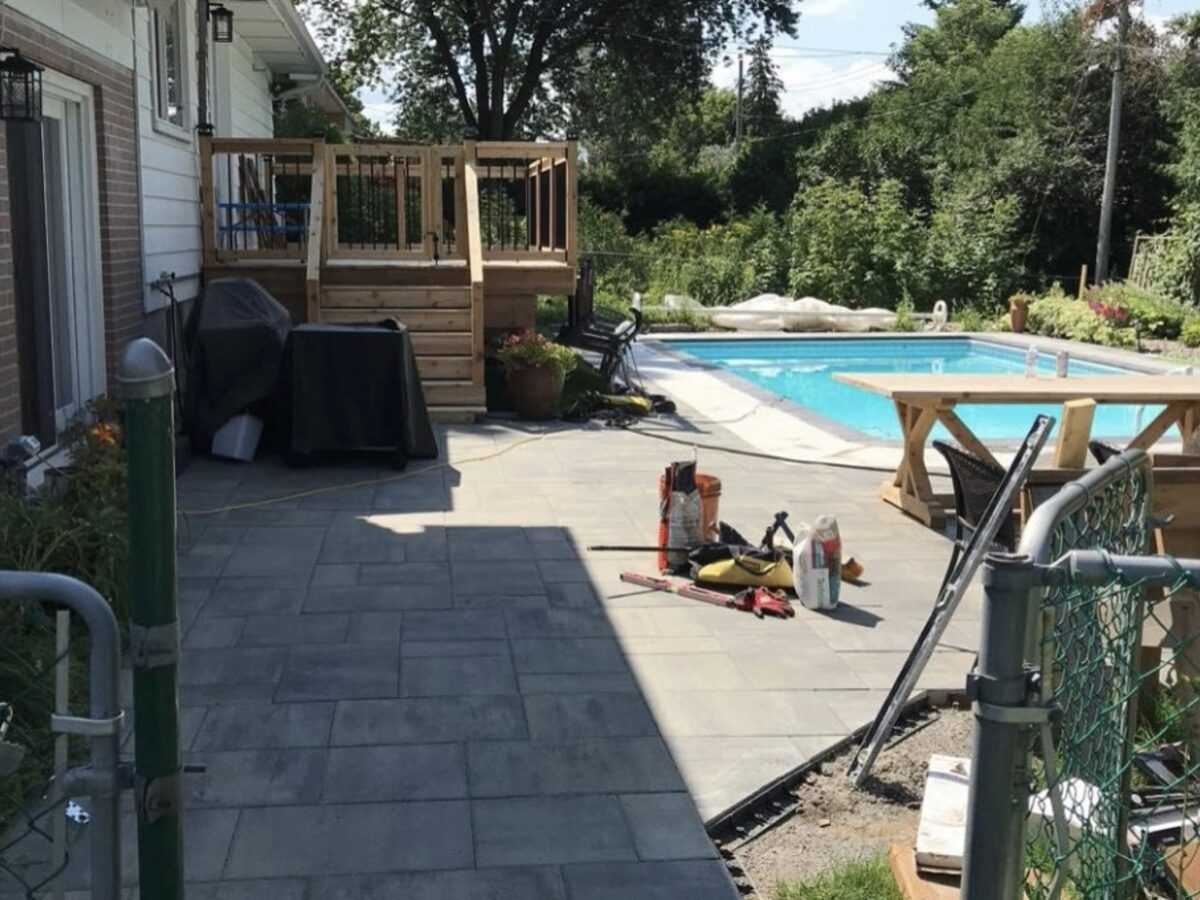 Poolside paver and patio work in a backyard